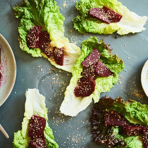 This salad is made with marinated beets and sesame seeds and lettuce leaves and slivered almonds.